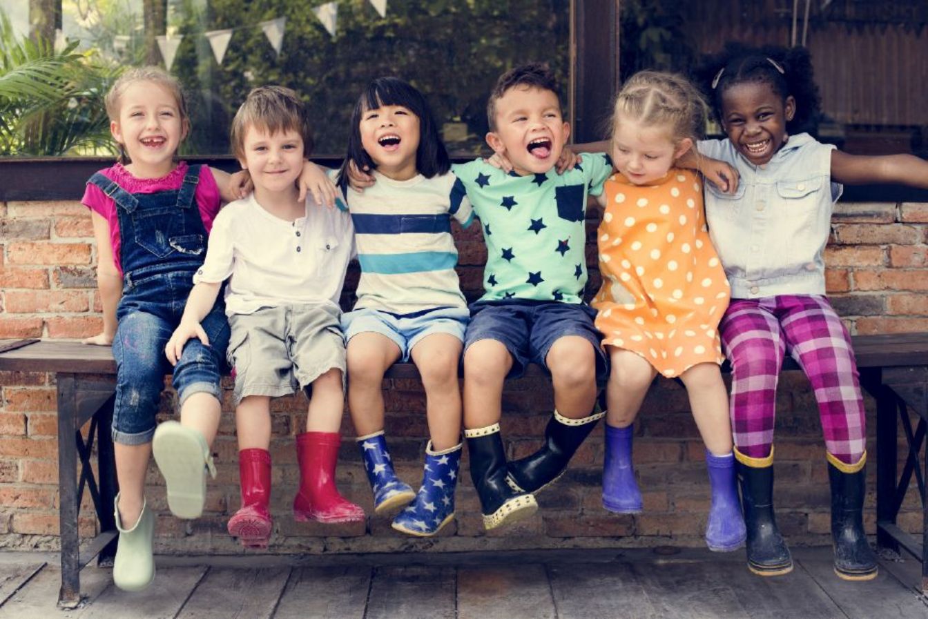 A bunch of kids sitting on a bench